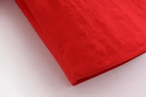 Gros plan des coutures de tissu rouge de haute qualité et de la finition de l'ourlet.