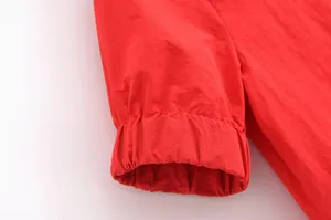 Gros plan du poignet élastique rouge sur une chemise d'automne tendance
