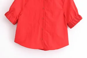 Vue macro détaillée d'une chemise rouge à manches courtes avec boutons et poignets élastiques