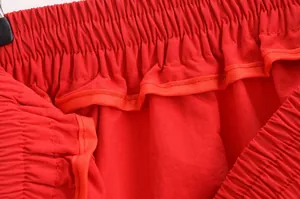 Détail de la taille élastique de la jupe rouge avec passepoil de couture intérieure.