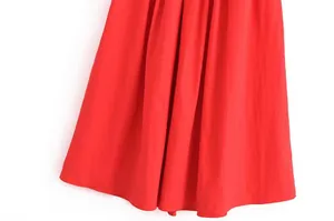 Gros plan détaillé sur l'ourlet d'une jupe rouge vif montrant la texture fine du tissu