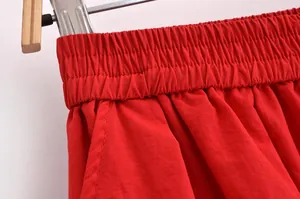 Détail de la taille élastique et des coutures fines sur un ensemble de jupe rouge pour femme
