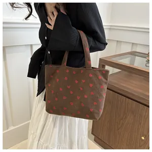Stylish brown corduroy tote bag featuring a cute strawberry print in a daily setting