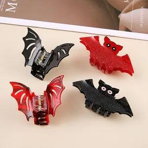 Detail of four spooky Halloween bat-shaped hair claws in black and red finishes.