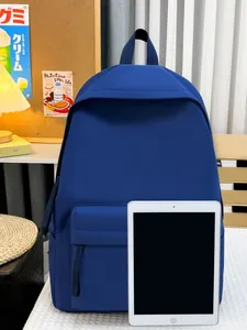 Minimalistischer blauer Schulrucksack mit großem Fassungsvermögen und iPad zum Größenvergleich.