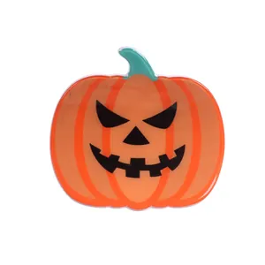Halloween pumpkin hair claw clip with spooky Jack-o'-lantern face and green stem design