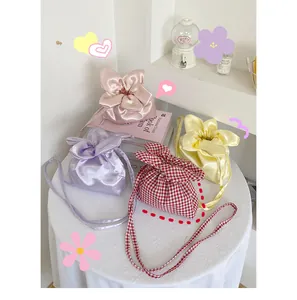Detailed view of cute flower-shaped crossbody bags in satin and gingham styles