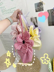 Close-up of flower-shaped fabric tote bags in colorful satin and gingham patterns