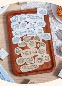 Detailansicht von Holzstempeln mit Backmotiven und deren Abdrücken auf Papierstreifen