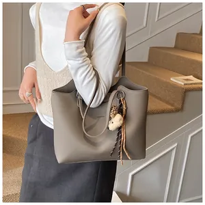 Elegant retro large capacity taupe leather tote bag with bear charm carried by model