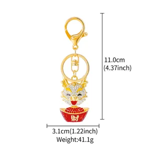 Macro detail of golden rhinestone dragon keychain with dimensions and weight info