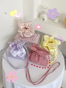 Cute floral petal-shaped drawstring crossbody pouch bags in satin and gingham fabrics.