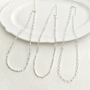 Primer plano de tres estilos diferentes de collares de cadena de plata para mujer.