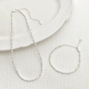 Primer plano de conjunto de collar y pulsera de plata minimalista con cuentas y corazones