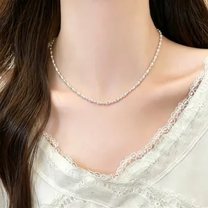 Detalle de primer plano de un collar de cuentas plateadas usado por una modelo elegante