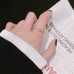 Détail d'une bague ouverte scintillante sertie de pavés portée à l'index, style élégant