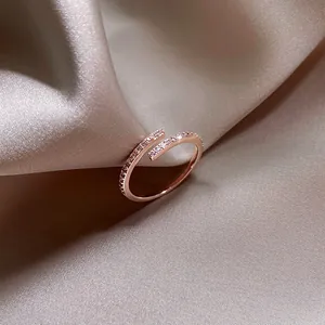 Vue détaillée d'une bague ajustable en or rose ornée de strass fins et scintillants.