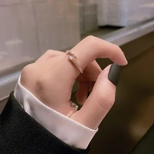 Gros plan d'une bague ouverte ajustable sertie de pavés brillants portée à l'index