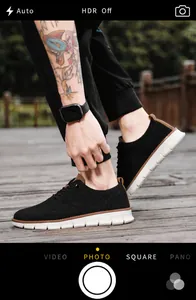 Primer plano de mocasines de punto negro transpirables para hombre en una plataforma.