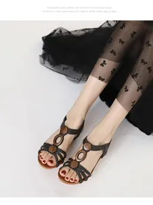 Detailed view of black wedge sandals featuring decorative wooden circles and soft brown insoles