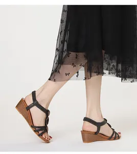 Close-up of black retro wedge sandals with Roman style straps and brown sole