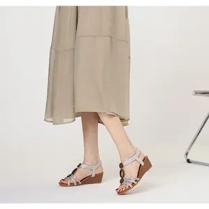 Detail view of silver women's wedge sandals with retro multi-strap Roman design