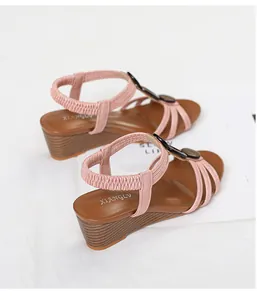 Detailed view of pink wedge sandals with elastic heel straps and soft soles