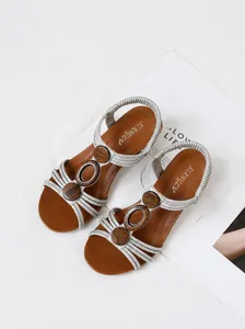 Detail view of stylish women's silver wedge sandals with retro wooden ring ornaments