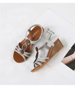 Close-up of silver strappy wedge sandals with wooden accents on a lifestyle book