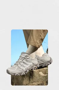Gros plan de chaussures de randonnée grises avec semelles robustes sur un rocher