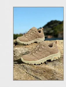 Gros plan de chaussures de randonnée kaki sur un rocher avec montagnes en arrière-plan