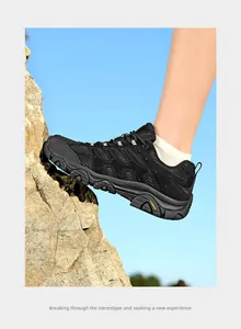 Vue détaillée de profil d'une chaussure de randonnée noire sur une roche escarpée.