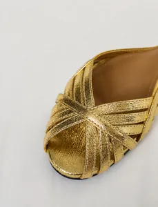Detailansicht des goldenen Metallic-Obermaterials aus weichem Leder bei Sandalen