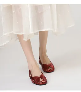 Detailansicht der metallisch roten flachen Slingback-Sandalen mit geflochtenem Riemen