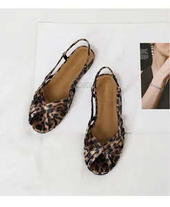 Detailansicht flacher Römersandalen mit Leopardenmuster, Kreuzriemen und Slingback-Riemen
