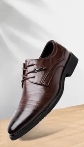 Dettaglio scarpe eleganti marroni da uomo in pelle goffrata con design stringato