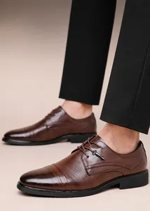 Dettaglio macro di scarpe eleganti da uomo in pelle marrone goffrata con lacci neri