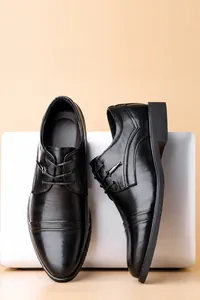 Dettaglio di scarpe business in pelle nera di qualità su sfondo bianco per laptop