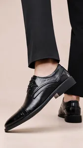 Dettaglio di scarpe business in pelle nera con motivi goffrati e chiusura stringata