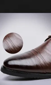 Vista macro dettagliata della pelle bovina marrone goffrata sulle scarpe eleganti da uomo.