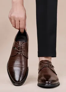Dettaglio di alta qualità di scarpe Oxford da uomo in pelle goffrata marrone con lacci a punta