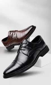 Dettaglio di scarpe eleganti da uomo in pelle goffrata nera e marrone con stringhe.