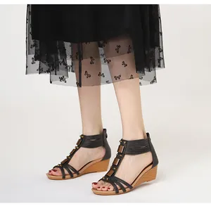 Detalle de sandalias de cuña negras para mujer con detalles de madera y cremallera