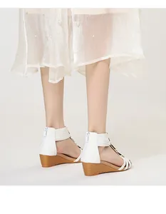 Vista posterior de sandalias de cuña blancas con tacón de madera y cremallera trasera