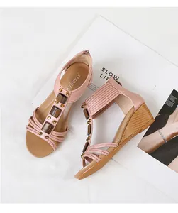 Vista detallada de sandalias de cuña rosas con cuentas de madera y cremallera trasera segura