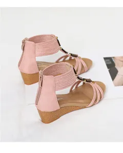 Detalle del cierre de cremallera trasera y cuña de sandalias de estilo romano en color rosa