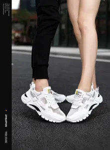 Detail view of white breathable mesh sneakers with casual sporty design for couples