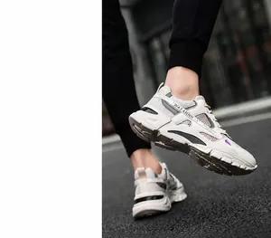 Close-up of breathable mesh men's sneaker in white and grey on model walking