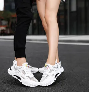 Close-up detail of breathable white mesh sneakers worn outdoors by a couple for a casual look