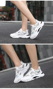 Detail view of breathable white mesh sneakers for men with thick shock-absorbing soles.